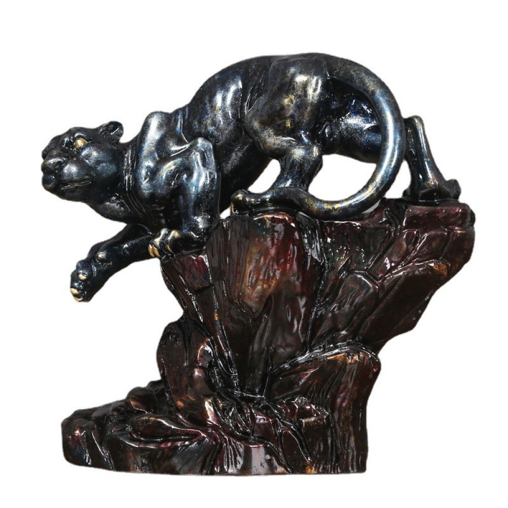 Art Deco style crouching panther statue with blue and metallic finishes, perched on a detailed rocky base (a symbol of strength & courage), displayed on a wooden surface against a gray background 01