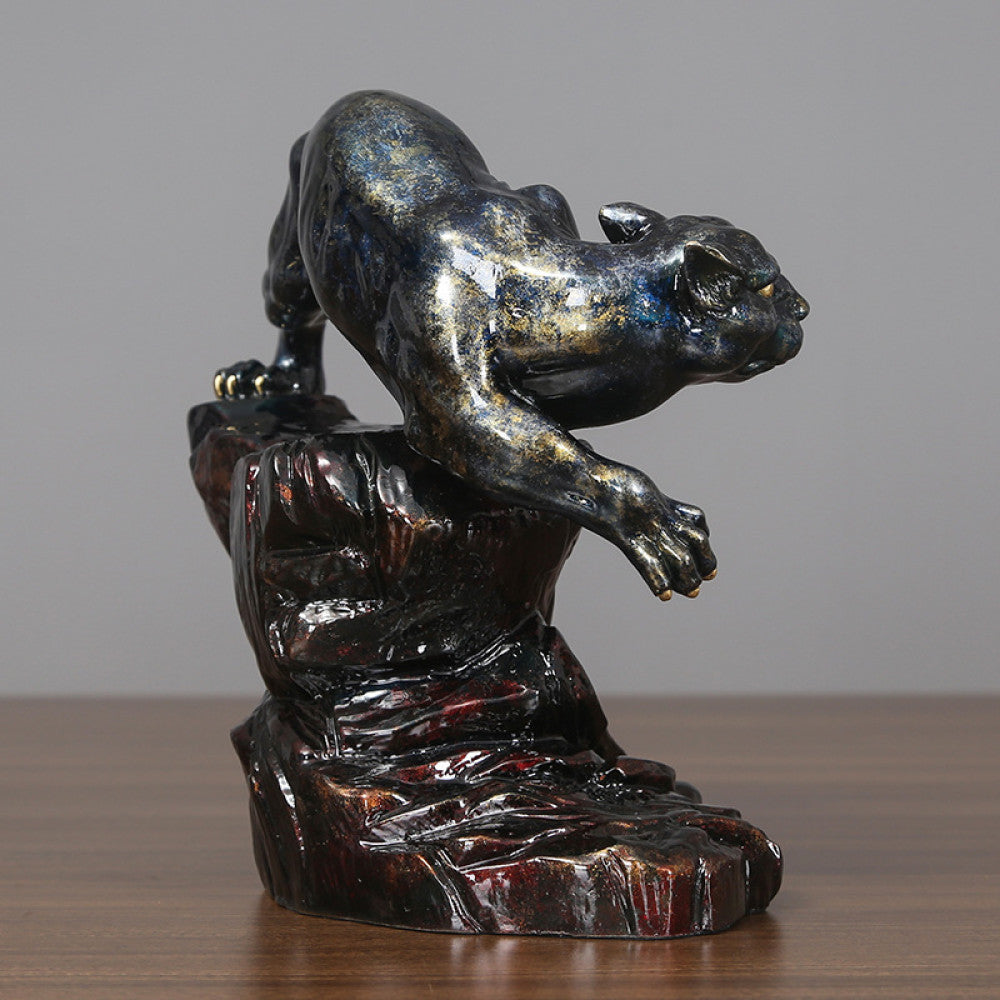 Art Deco style crouching panther statue with blue and metallic finishes, perched on a detailed rocky base (a symbol of strength & courage), displayed on a wooden surface against a gray background 02