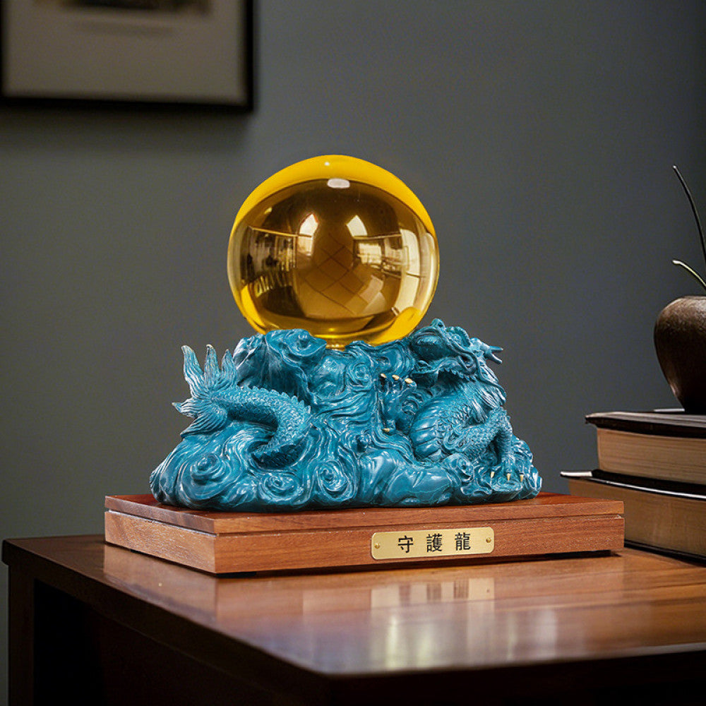 Blue dragon crystal ball statue with intricate carvings, a Feng Shui symbol of good fortune, displayed as elegant home decor on a wooden base in an office setting against a gray background 01