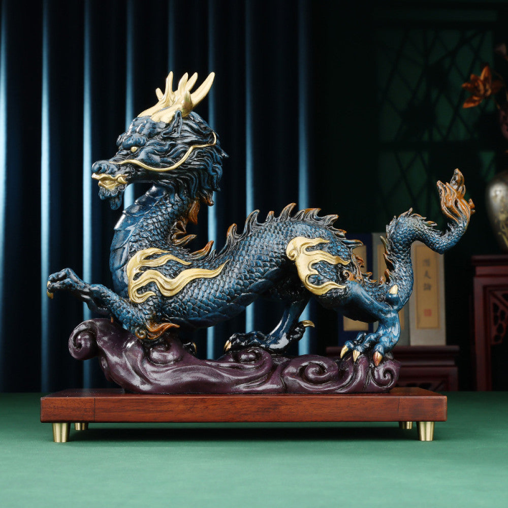 Blue and gold Chinese dragon statue with intricate golden details, a Feng Shui symbol of good fortune and strength, displayed on a wooden base as elegant home decor against a dark background