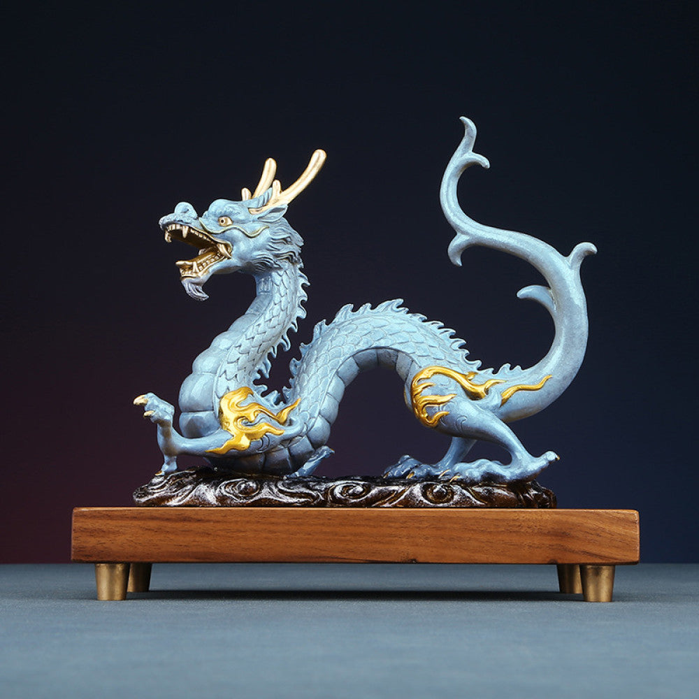 Blue Chinese dragon statue with golden accents, a Feng Shui symbol of good fortune and strength, displayed on a wooden base as elegant home decor against a dark background