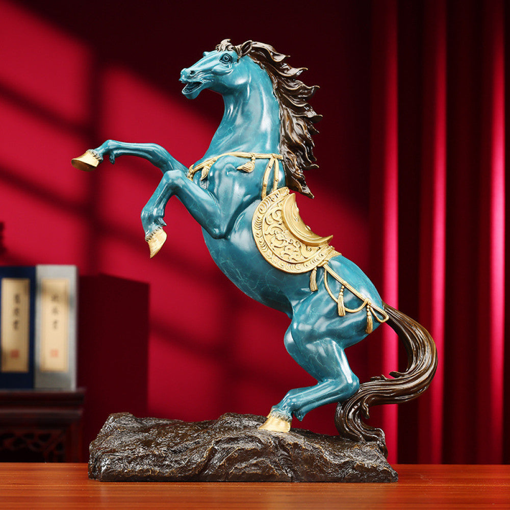 Blue horse statue with golden accents, a Feng Shui symbol of success and good fortune, displayed as elegant home decor against a red background