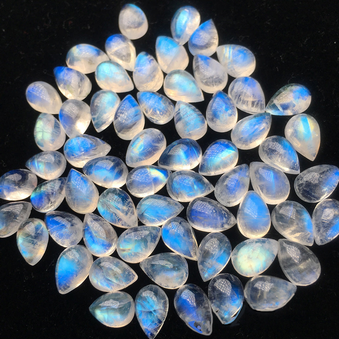 Teardrop-shaped moonstone, with a gorgeous blue moonlight effect, is displayed in large quantities to show the charm of the gemstone