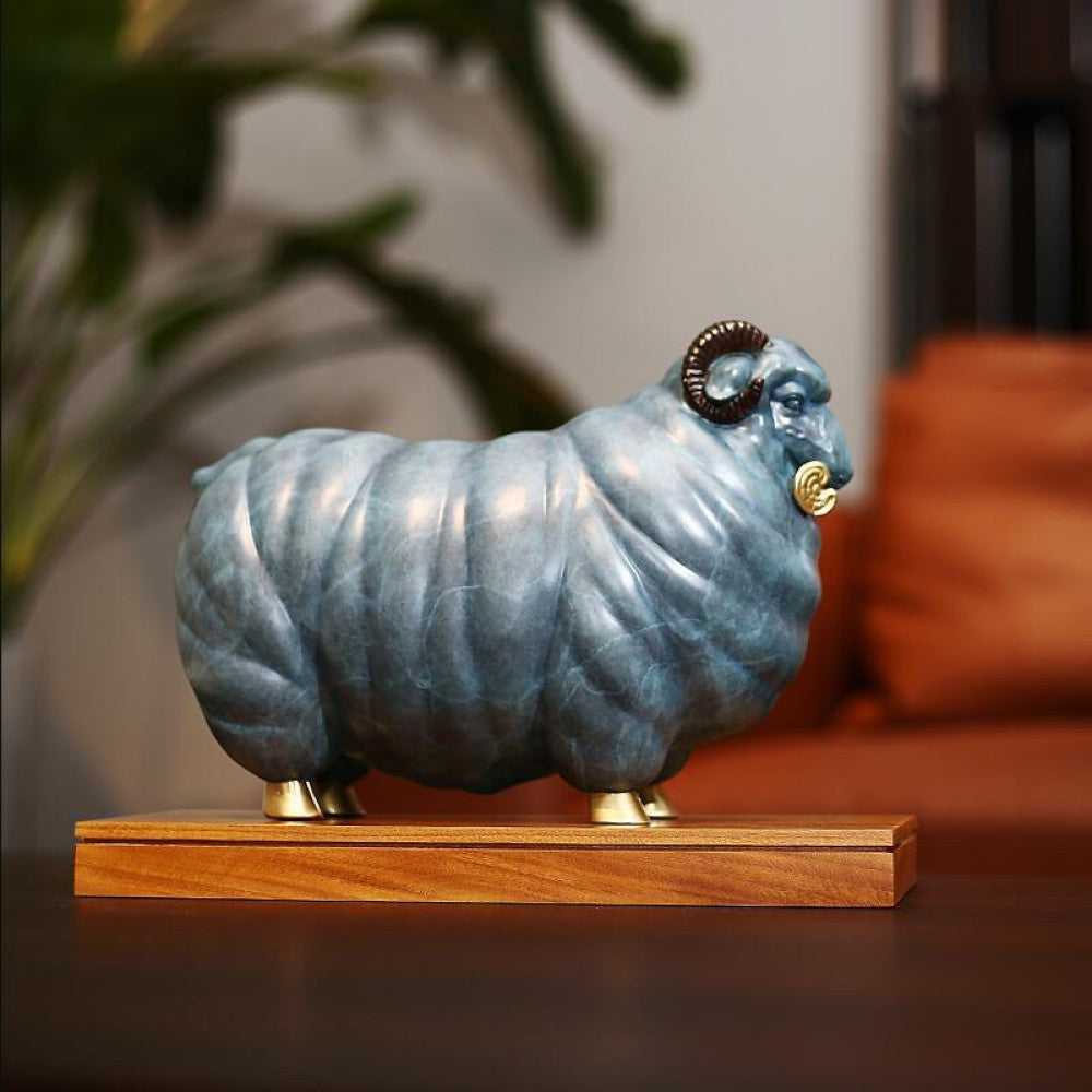 Blue ram statue with golden accents, a Feng Shui symbol of wealth and good fortune, displayed as stylish home decor on a wooden base in a living room setting