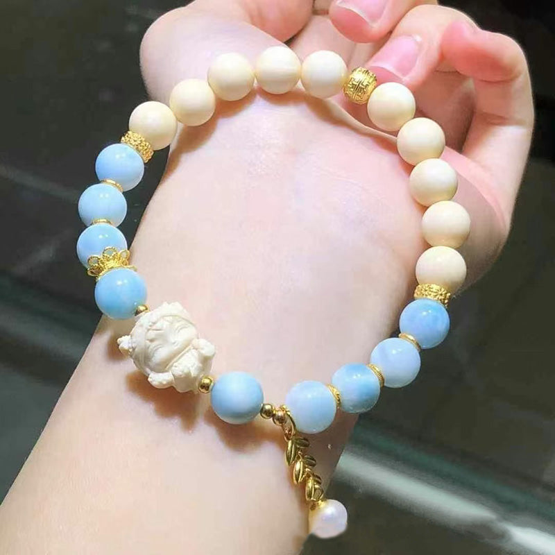 Boho bracelet with blue gemstone beads, carved charm, gold details