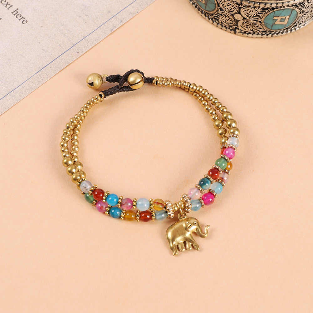 This double-layered bohemian bracelet features vibrant multicolored beads, golden bells, and a charming gold elephant charm. The adjustable knot closure ensures a perfect fit, adding a playful, ethnic-inspired touch to any outfit 4