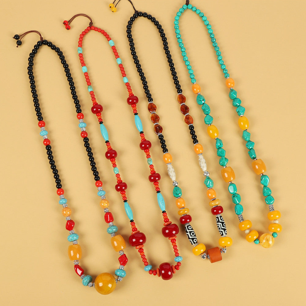 Assorted bohemian ethnic tribal multi-color beaded necklace set with vibrant red, turquoise, yellow, and black beads, displayed against a neutral background, ideal for boho fashion enthusiasts