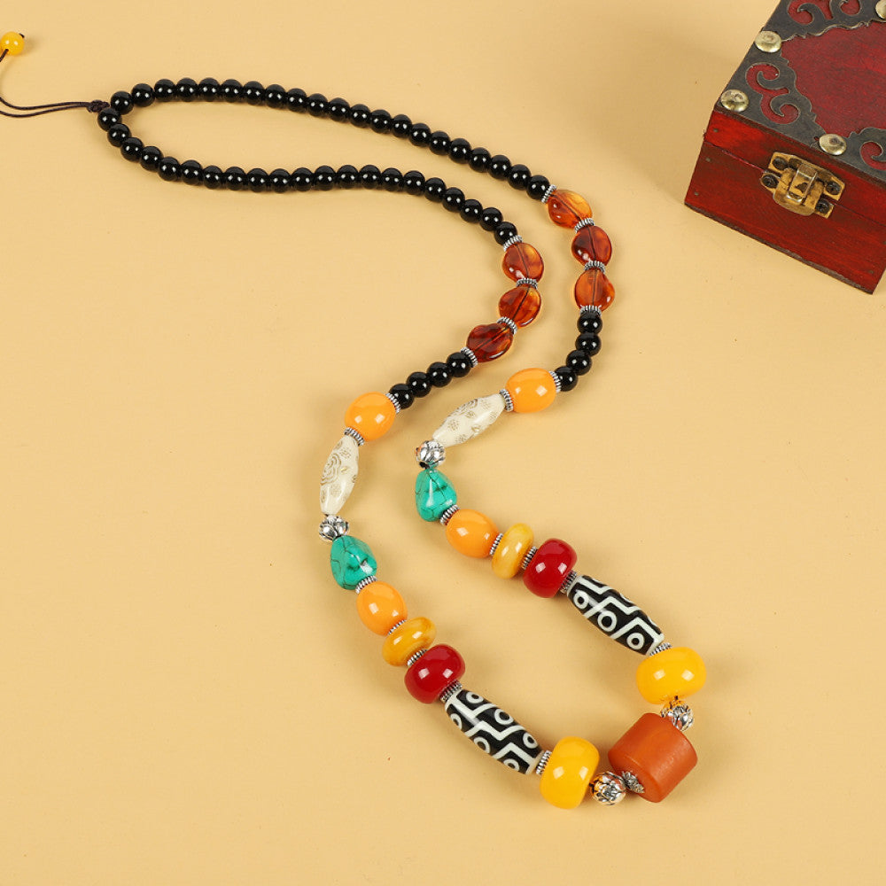 Vintage bohemian ethnic tribal necklace with multi-color beads (black, orange, red, turquoise, yellow) and intricate patterned accents, ideal for boho chic fashion, displayed against a neutral background with a vintage box accent