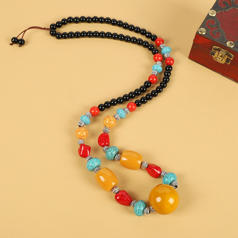 Vintage bohemian ethnic tribal necklace with multi-color beads (black, orange, red, turquoise, yellow) and intricate patterned accents, ideal for boho chic fashion, displayed against a neutral background with a vintage box accent 01