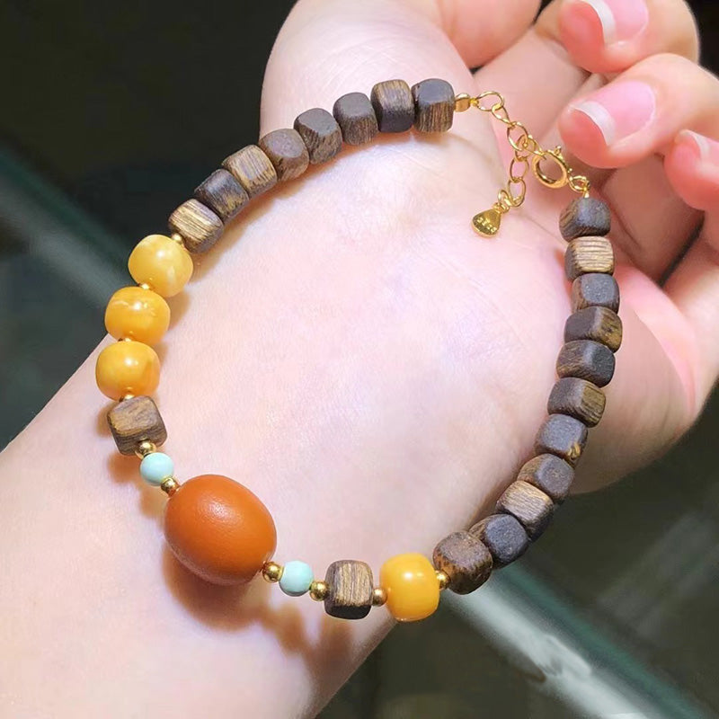 Handmade bohemian bracelet featuring wooden beads, amber beads, and gold clasp