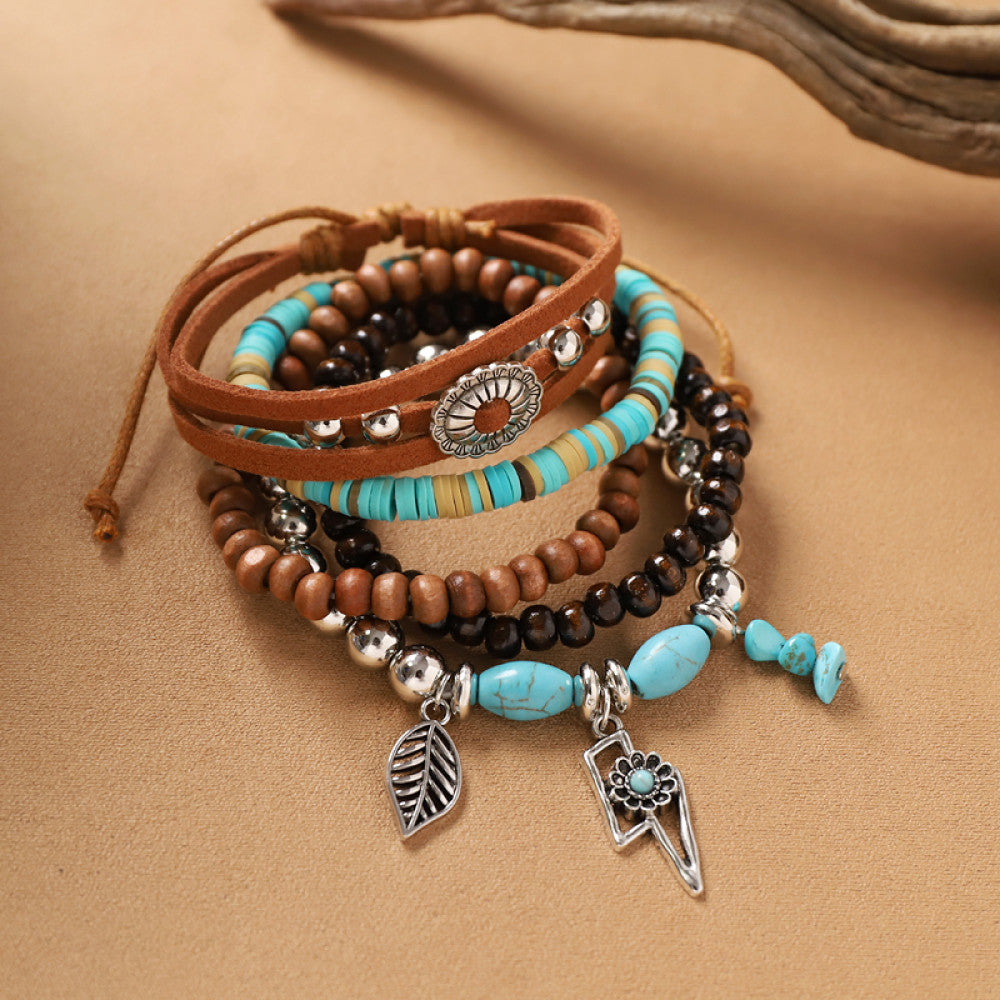 This bohemian stackable bracelet set features multiple layered strands in earthy tones, including turquoise, dark brown, green, and light brown beads, accented with decorative silver elements. The mix of natural materials and ethnic-inspired details creates a rich, textured look, perfect for layering to elevate casual outfits 01