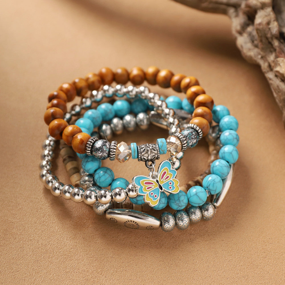 This bohemian stackable bracelet set features multiple layered strands in earthy tones, including turquoise, dark brown, green, and light brown beads, accented with decorative silver elements. The mix of natural materials and ethnic-inspired details creates a rich, textured look, perfect for layering to elevate casual outfits 06
