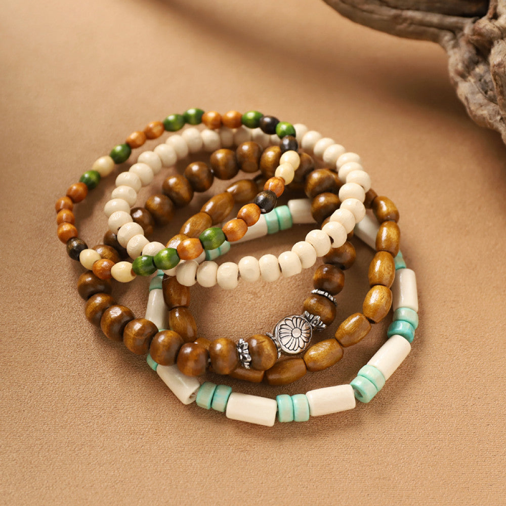 This bohemian stackable bracelet set features multiple layered strands in earthy tones, including turquoise, dark brown, green, and light brown beads, accented with decorative silver elements. The mix of natural materials and ethnic-inspired details creates a rich, textured look, perfect for layering to elevate casual outfits 8