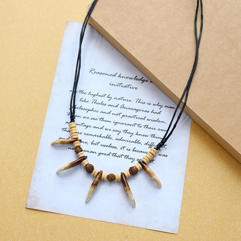 Vintage bohemian tribal necklace with bone accents and black cord, displayed on vintage paper, ideal for ethnic wilderness and boho fashion 02