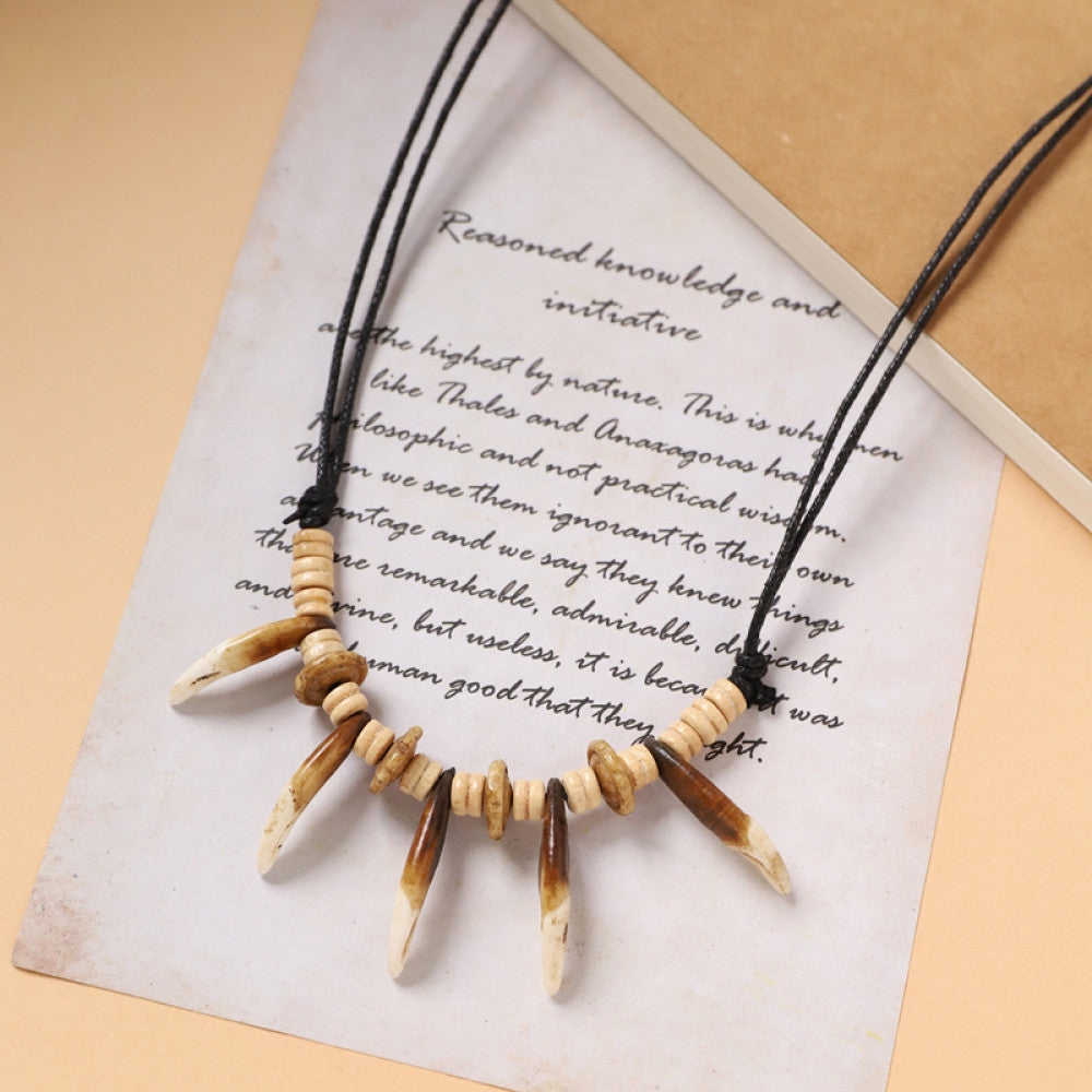 Vintage bohemian tribal necklace with bone accents and black cord, displayed on vintage paper, ideal for ethnic wilderness and boho fashion 05