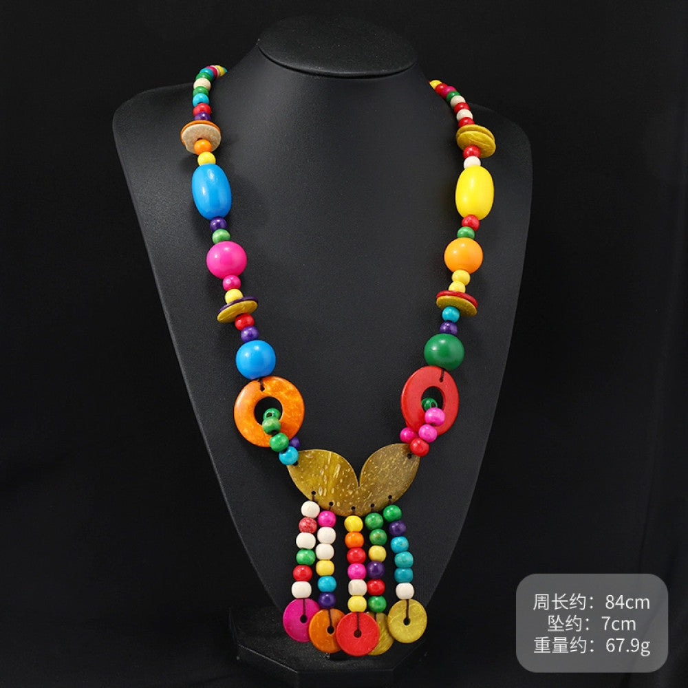 Vintage bohemian colorful shell and beaded necklace with tropical floral pendant, featuring multi-color beads and shell accents, ideal for boho beach and ethnic fashion, displayed on a black mannequin against a dark background 01