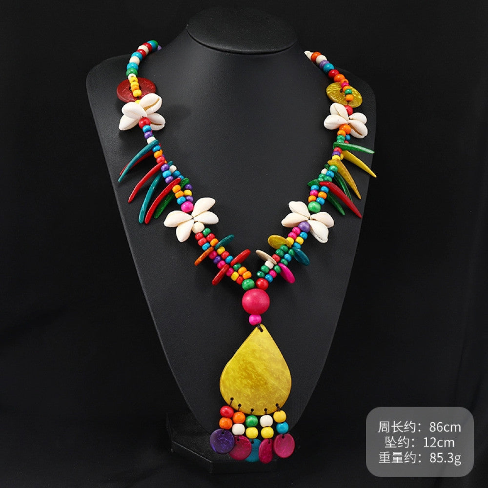 Vintage bohemian colorful shell and beaded necklace with tropical floral pendant, featuring multi-color beads and shell accents, ideal for boho beach and ethnic fashion, displayed on a black mannequin against a dark background 04