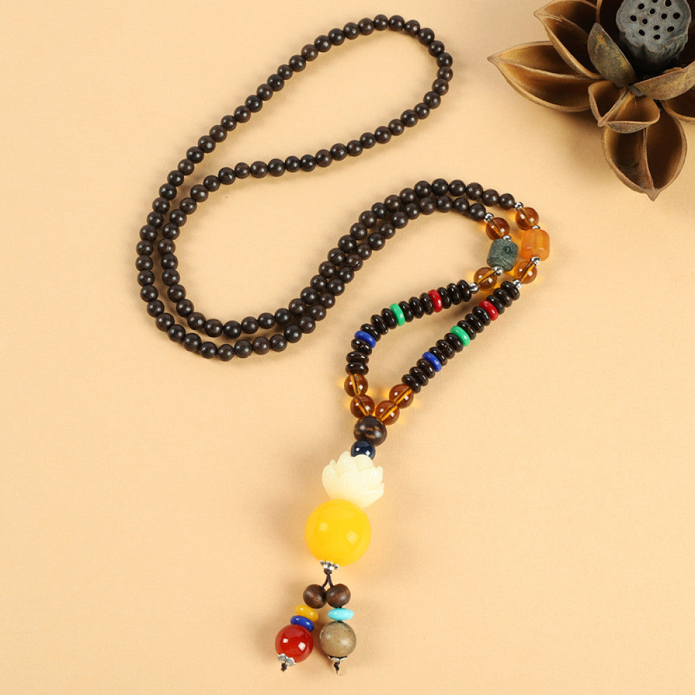 Vintage bohemian ethnic beaded necklace with red pendant and multi-color beads, ideal for spiritual boho fashion, displayed with a decorative flower against a neutral background 01