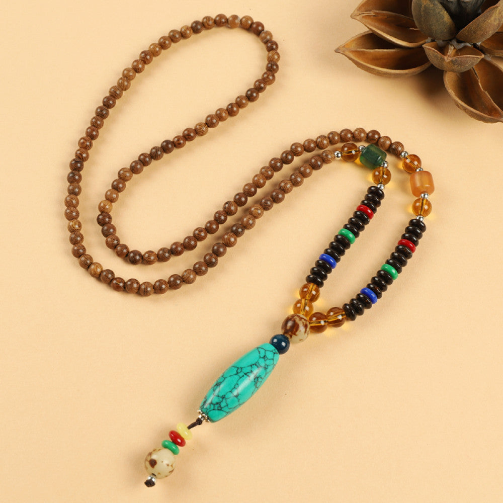 Vintage bohemian ethnic beaded necklace with red pendant and multi-color beads, ideal for spiritual boho fashion, displayed with a decorative flower against a neutral background 07