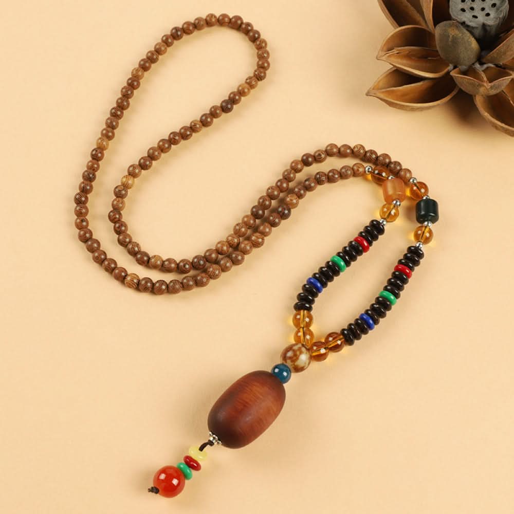 Vintage bohemian ethnic beaded necklace with red pendant and multi-color beads, ideal for spiritual boho fashion, displayed with a decorative flower against a neutral background 10
