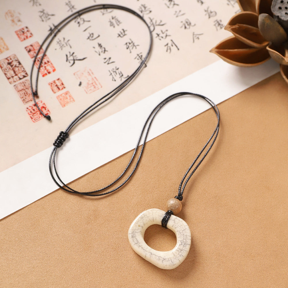 Vintage bohemian ethnic necklace with unique Chinese-style square pendant, featuring earthy tones and black cord, displayed with traditional Chinese calligraphy and decorative flower, ideal for spiritual boho and ethnic fashion enthusiasts 01