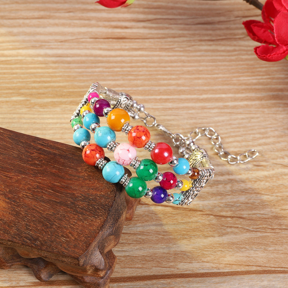 Vintage bohemian ethnic colorful beaded bracelet with multi-color stone beads and silver accents, displayed on a wooden surface, ideal for boho fashion enthusiasts