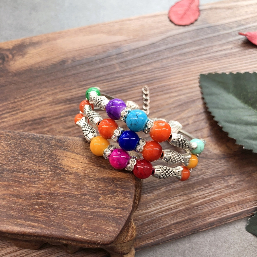 Vintage bohemian ethnic colorful beaded bracelet set with silver fish accents, displayed on a wooden surface, ideal for boho fashion enthusiasts