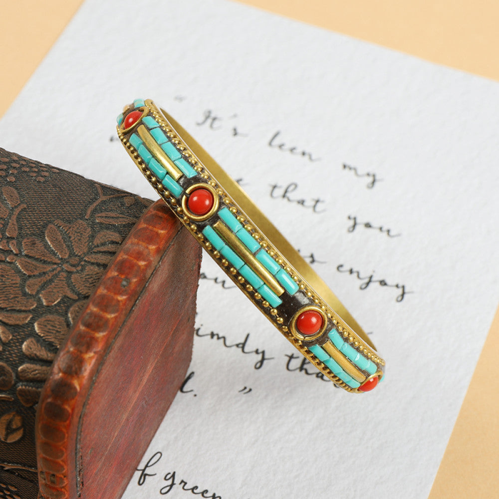 Vintage bohemian ethnic enamel bangle with turquoise and red stone inlays, gold-tone accents, displayed on a vintage box with decorative text, ideal for boho fashion enthusiasts