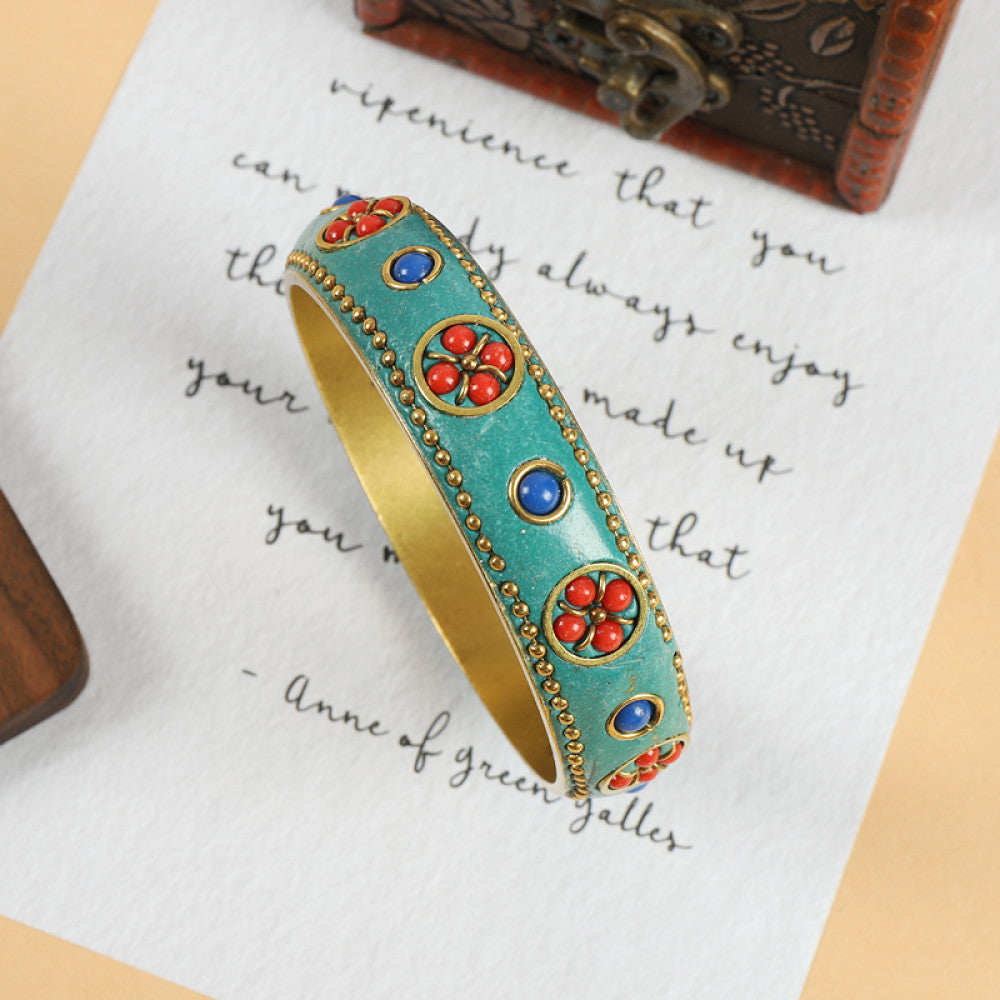 Vintage bohemian ethnic enamel bangle with turquoise and red stone inlays, gold-tone textured design, displayed on paper with decorative text and a vintage box, ideal for boho fashion enthusiasts 04