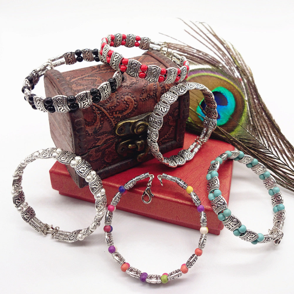 Assorted bohemian vintage ethnic beaded bracelet set with black, red, silver, multi-color, turquoise designs, displayed with a vintage box and peacock feathers, ideal for boho fashion enthusiasts