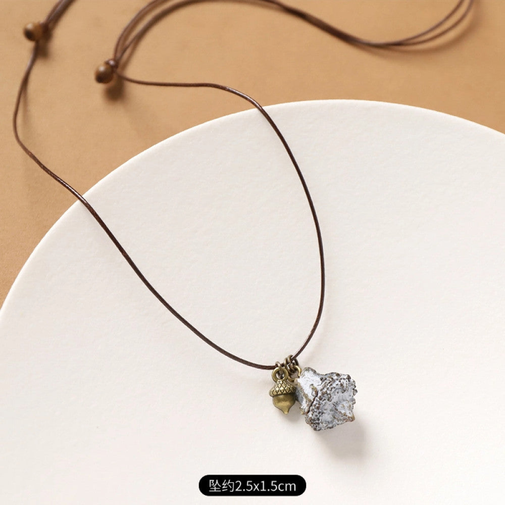 Vintage bohemian ethnic necklace with natural seed pendant, featuring earthy brown tones and cord design, displayed on a white plate against a neutral background, ideal for boho fashion enthusiasts 05