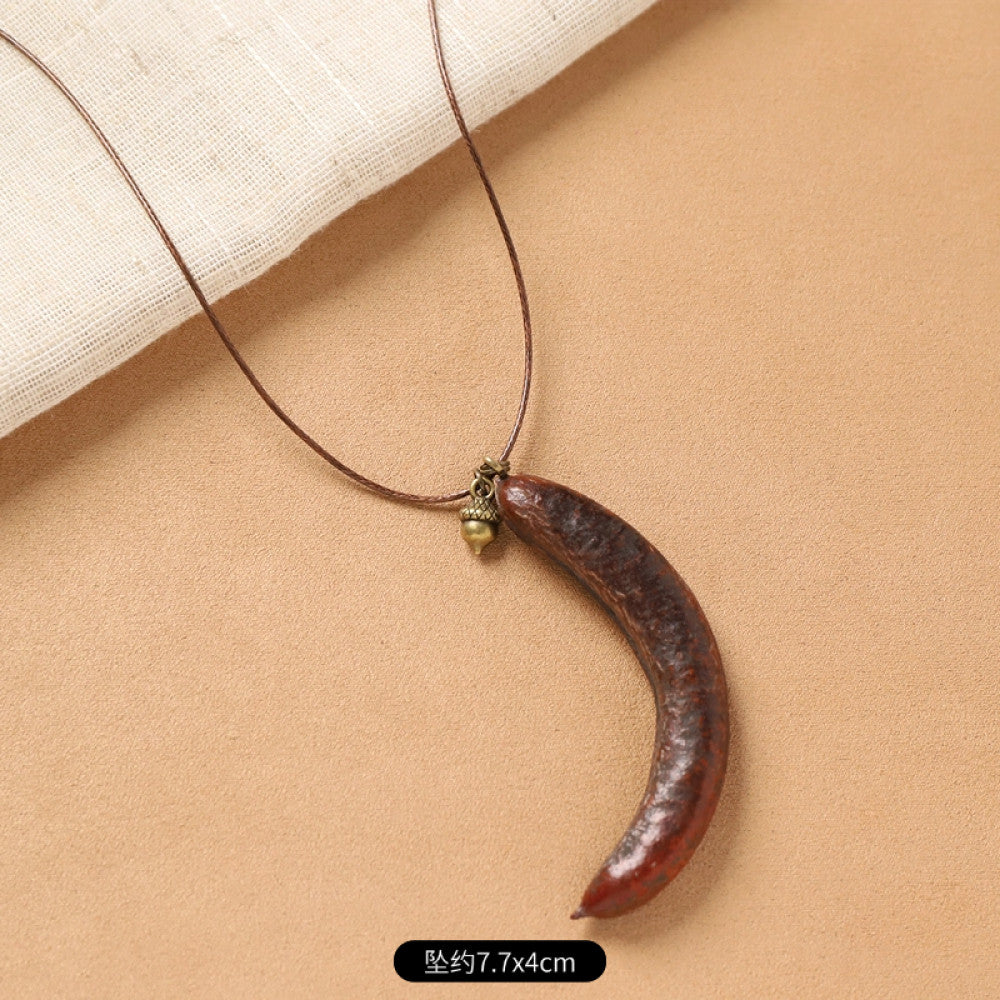 Vintage bohemian ethnic necklace with natural seed pendant, featuring earthy brown tones and cord design, displayed on a white plate against a neutral background, ideal for boho fashion enthusiasts 07