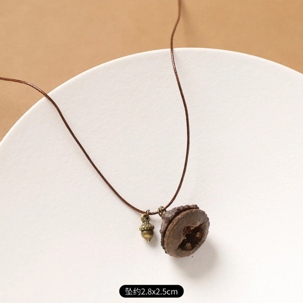 Vintage bohemian ethnic necklace with natural seed pendant, featuring earthy brown tones and cord design, displayed on a white plate against a neutral background, ideal for boho fashion enthusiasts 09