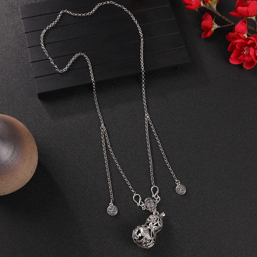 Vintage bohemian ethnic silver-tone necklace with Double Happiness pendant and filigree details, displayed on a dark background with red flowers, ideal for boho fashion and cultural-inspired styling 02