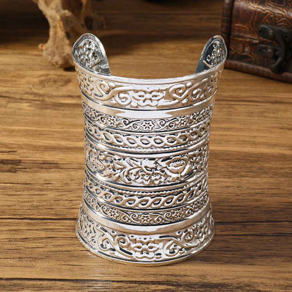 Vintage bohemian ethnic silver-tone engraved cuff bracelet with ornate tribal designs, displayed on a wooden surface with decorative elements, ideal for boho and ethnic fashion enthusiasts 06