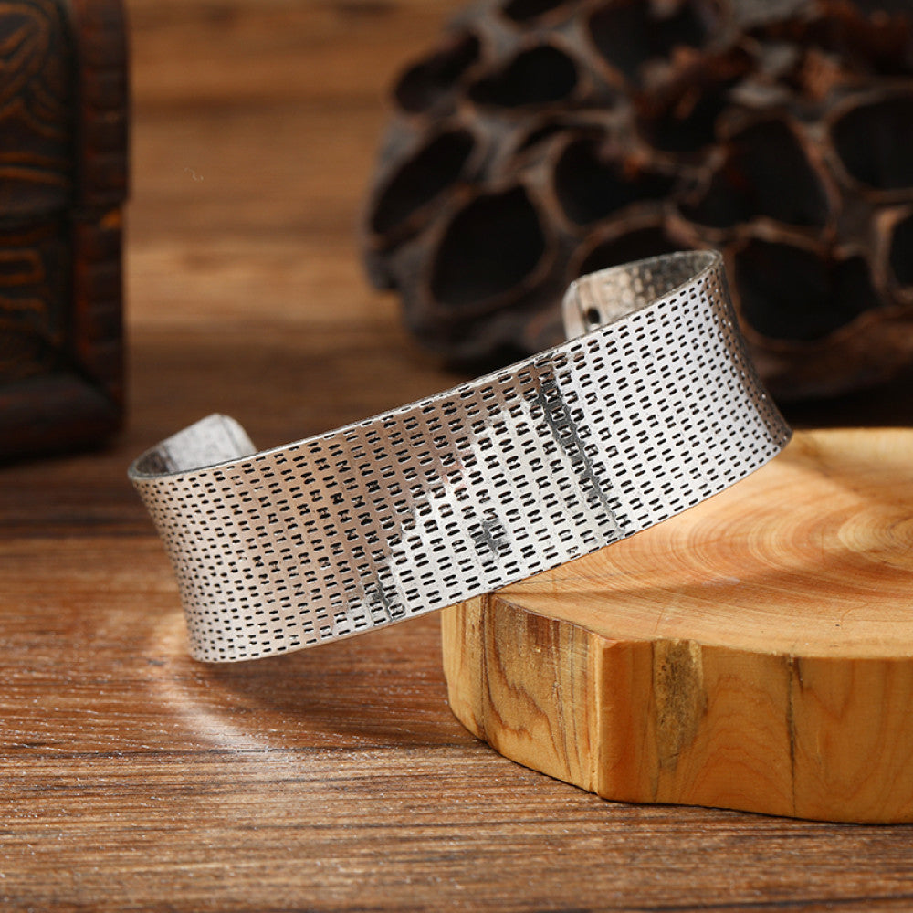 Vintage bohemian ethnic silver-tone cuff bracelet with intricate engraved floral designs, displayed on a wooden surface with rustic decor, ideal for boho and ethnic fashion enthusiasts 04