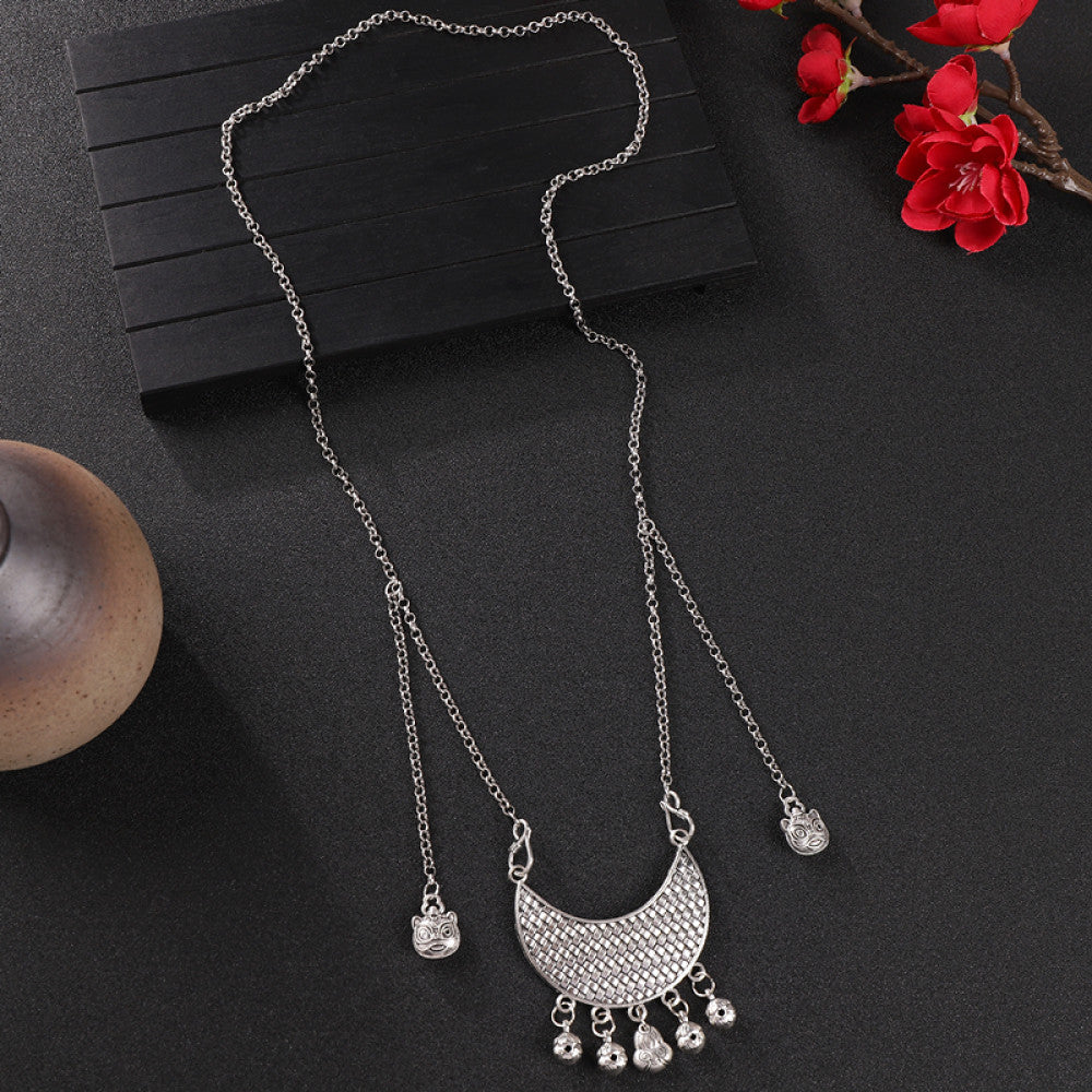 Vintage bohemian ethnic silver-tone necklace with intricate filigree, tassel bells, and ornate pendant, displayed on a dark background with red flowers and decorative accents, ideal for boho and ethnic fashion enthusiasts 06