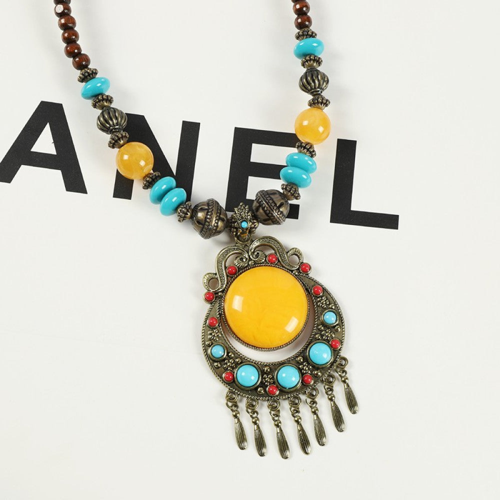 Vintage bohemian ethnic necklace with large red pendant, turquoise details, and tassel design, featuring antique bronze finish, ideal for boho fashion, displayed with floral and text accents against a white background 04