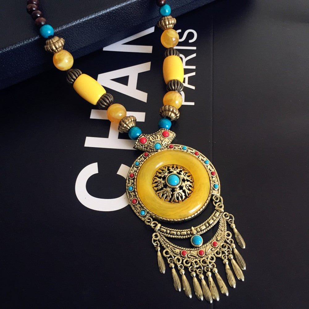 Vintage bohemian ethnic necklace with large red pendant, turquoise details, and tassel design, featuring antique bronze finish, ideal for boho fashion, displayed with floral and text accents against a white background 05