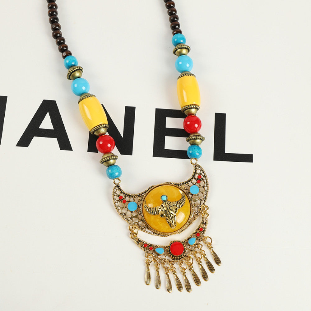 Vintage bohemian ethnic necklace with red pendant, turquoise accents, and tassel design, featuring antique bronze details, displayed against a black background with fashion text and Eiffel Tower accent, ideal for boho fashion enthusiasts 02