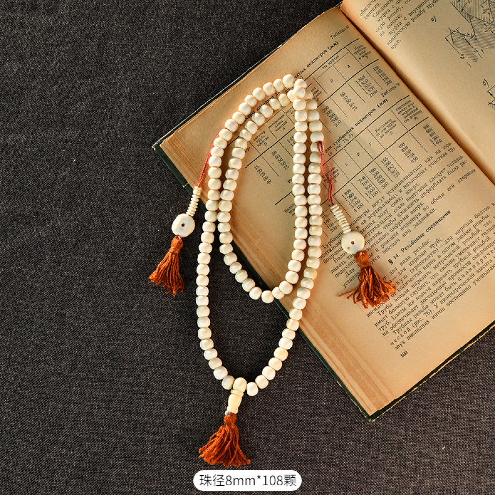 Vintage bohemian ethnic tribal multi-layer beaded necklace with turquoise accents and red tassels, displayed on an old book, ideal for spiritual boho fashion and layering 02