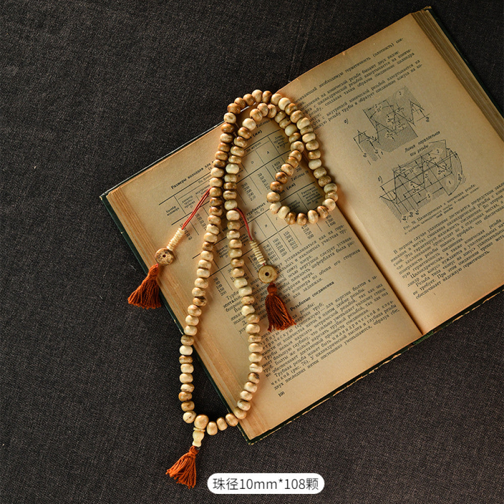 Vintage bohemian ethnic tribal multi-layer beaded necklace with turquoise accents and red tassels, displayed on an old book, ideal for spiritual boho fashion and layering 04