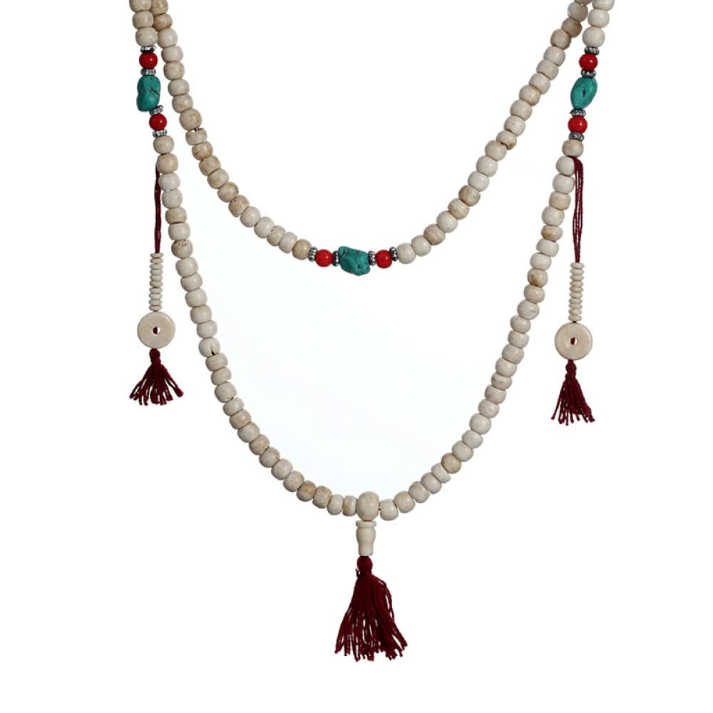 Vintage bohemian ethnic tribal multi-layer beaded necklace with turquoise accents and red tassels, displayed on an old book, ideal for spiritual boho fashion and layering 05