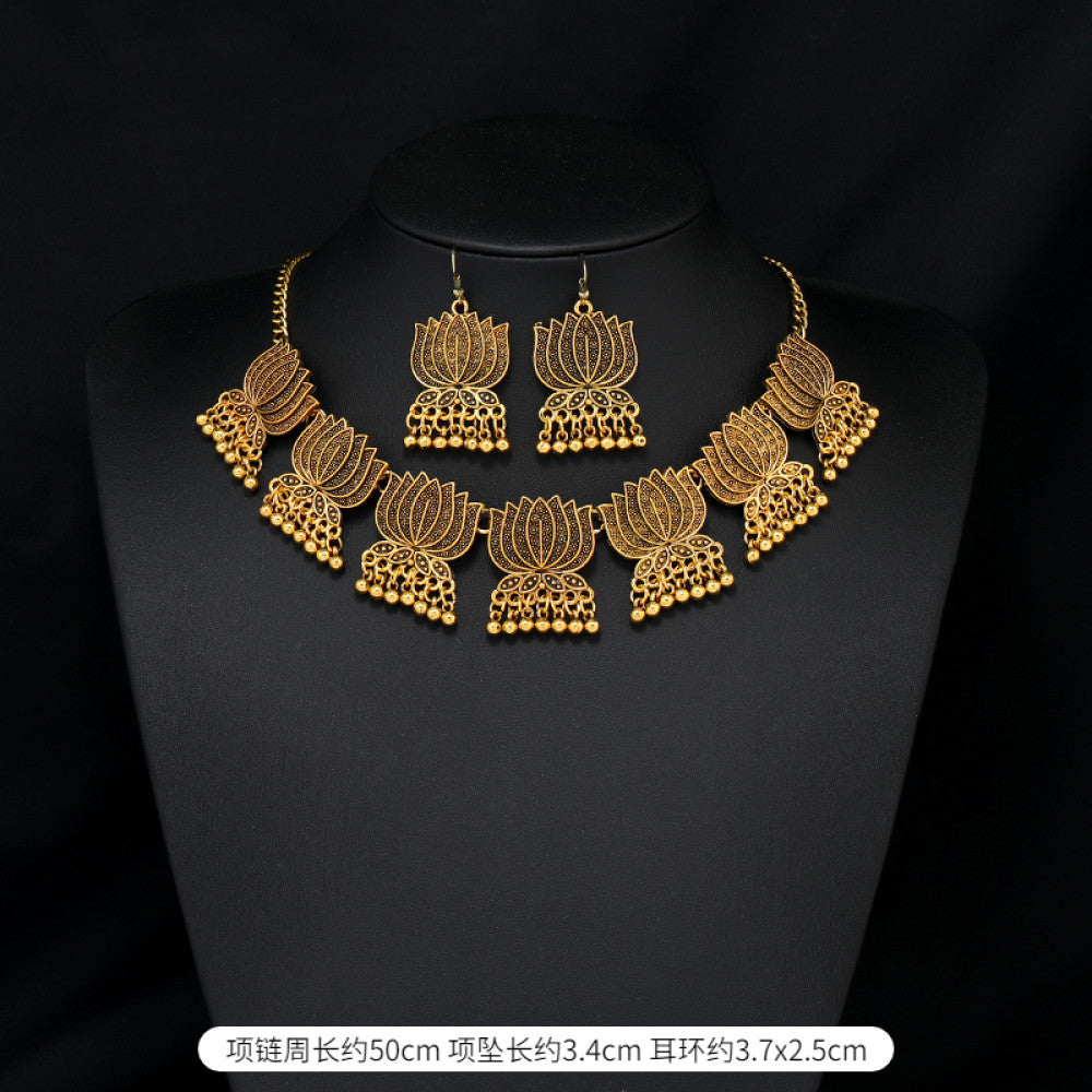 Vintage bohemian ethnic gold-tone necklace and earring set with intricate jhumka design, ideal for traditional or boho-chic occasions, displayed on a black mannequin against a dark background 01