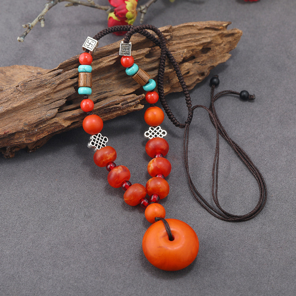 Vintage bohemian ethnic tribal necklace featuring a red circular pendant, intricate silver detailing, and braided rope design, perfect for boho fashion, showcased against a neutral background 02