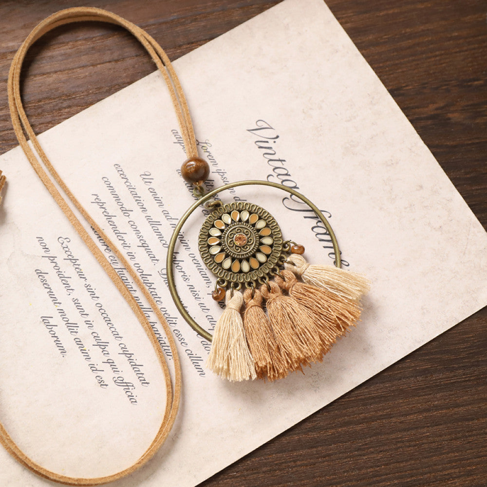 Vintage bohemian tassel necklace with earthy tone fringe and intricate pendant, displayed on vintage paper, ideal for boho fashion enthusiasts 01
