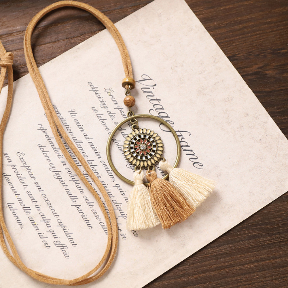 Vintage bohemian tassel necklace with earthy tone fringe and intricate pendant, displayed on vintage paper, ideal for boho fashion enthusiasts 03