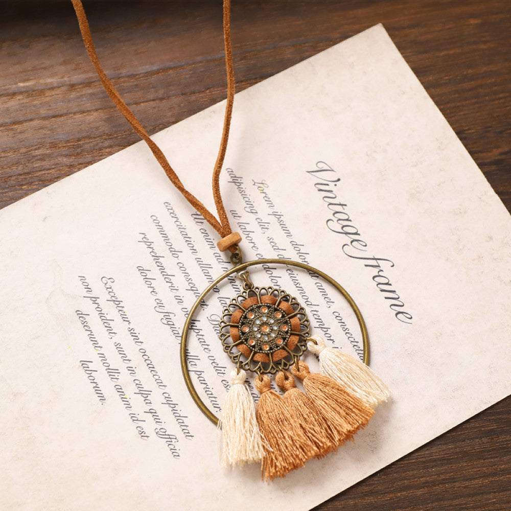 Vintage bohemian tassel necklace with earthy tone fringe and intricate pendant, displayed on vintage paper, ideal for boho fashion enthusiasts 05