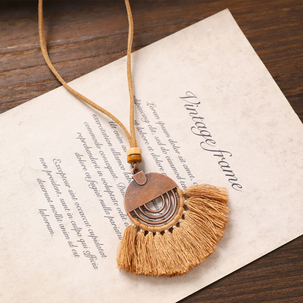 Vintage bohemian tassel necklace with earthy tone fringe and intricate pendant, displayed on vintage paper, ideal for boho fashion enthusiasts 07