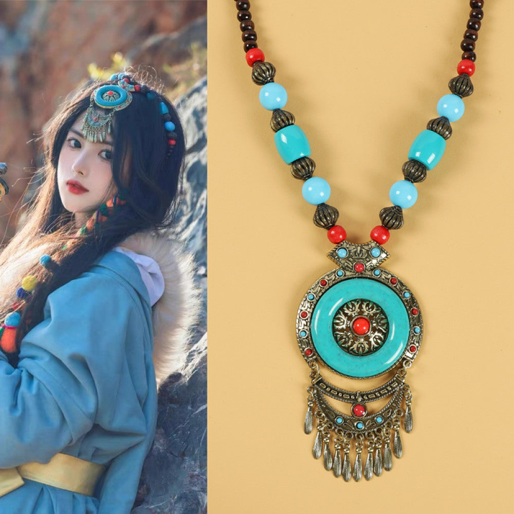 Ethnic tribal style necklace with large circular turquoise pendant, colorful beaded design, and tassel details, ideal for bohemian vintage fashion, displayed alongside a model in traditional ethnic attire 02